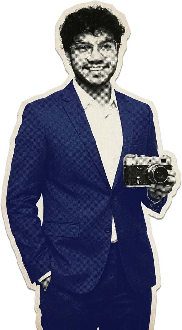 Jayesh Pradhan in a navy suit, holding a film camera: a halftone paper cut-out.
